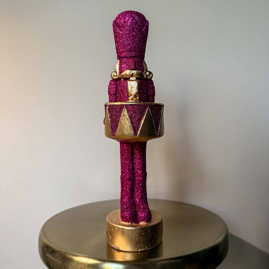 Decoratieve notenkraker voor de feestdagen in goud met roze details.